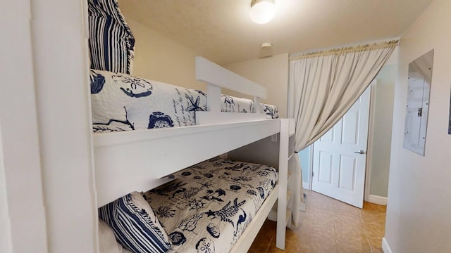 16819 Front Beach Rd Unit 210, Panama City Beach, FL 32413 - bedroom with electric panel, baseboards, and light tile patterned floors