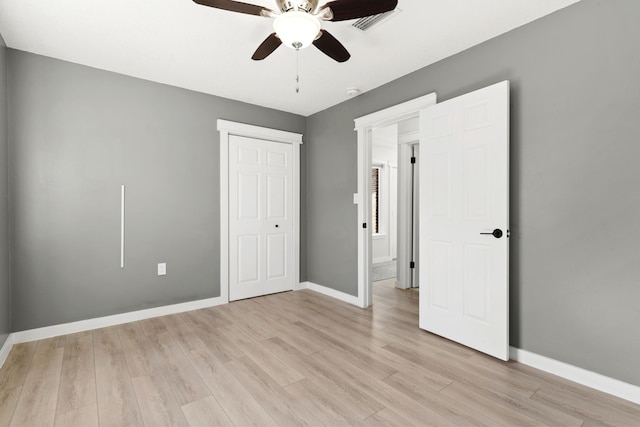 unfurnished bedroom featuring light wood finished floors, visible vents, baseboards, a closet, and a ceiling fan