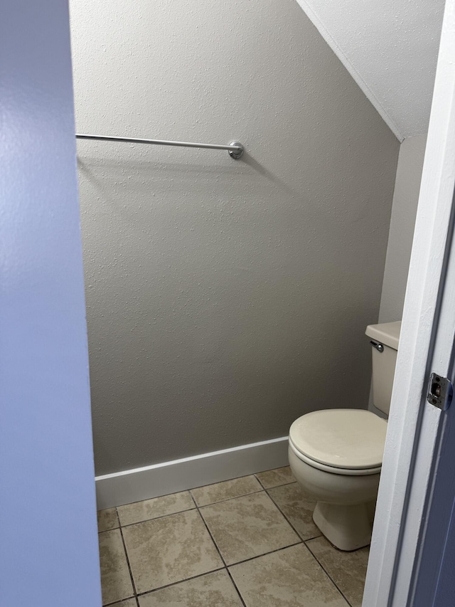 bathroom featuring baseboards, toilet, and tile patterned flooring