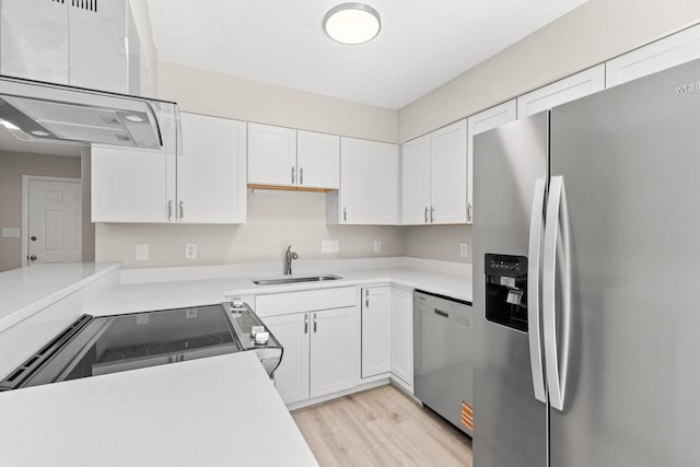 kitchen featuring white cabinetry, light countertops, appliances with stainless steel finishes, and a sink