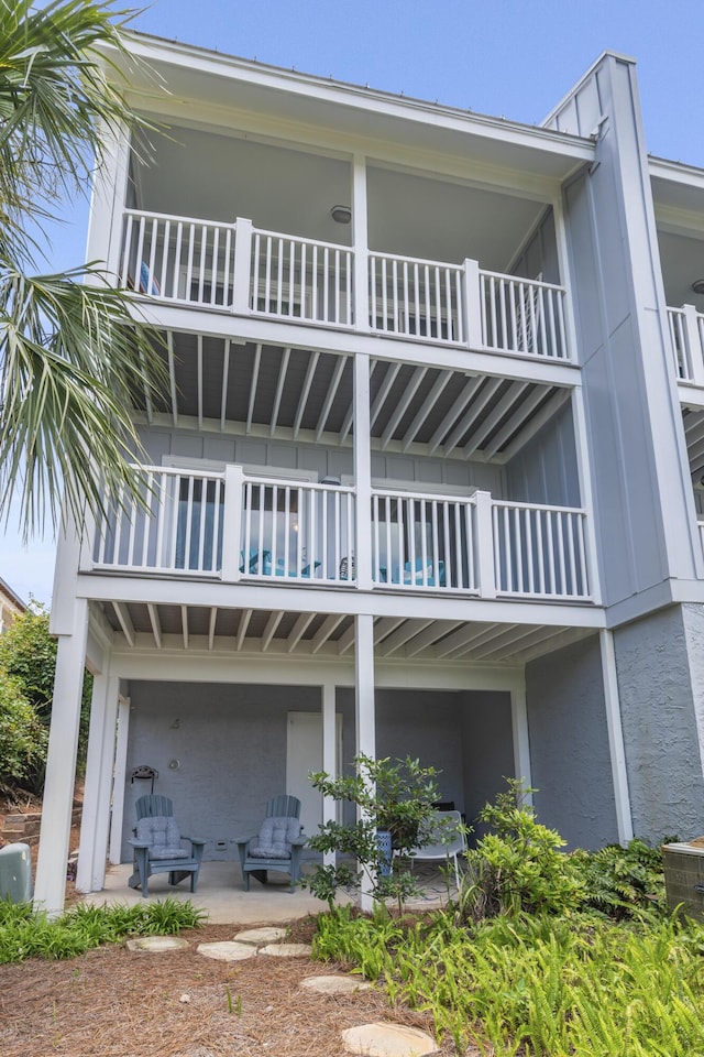 2381 W County Highway 30a Unit 8, Santa Rosa Beach, FL 32459 - back of house with a balcony, a patio, and board and batten siding