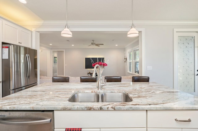 kitchen with pendant lighting, a ceiling fan, a sink, open floor plan, and stainless steel appliances