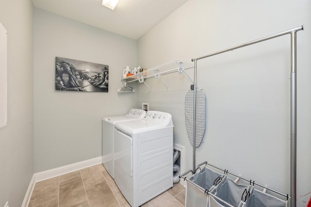 washroom featuring washing machine and clothes dryer, laundry area, and baseboards
