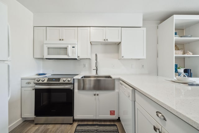 145 Beachfront Trl Unit 102A, Santa Rosa Beach, FL 32459 - kitchen with white cabinets, a sink, white appliances, wood finished floors, and light stone counters