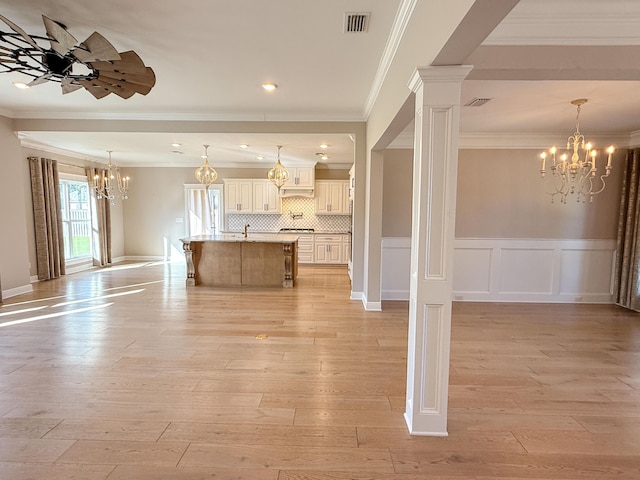 kitchen featuring light wood-type flooring, visible vents, open floor plan, an inviting chandelier, and a breakfast bar area