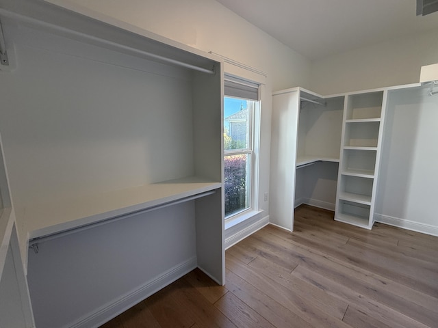walk in closet with visible vents and wood finished floors