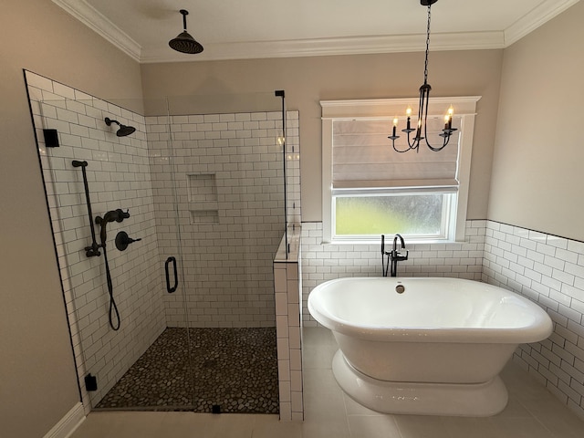 bathroom featuring a chandelier, a stall shower, crown molding, and a freestanding tub
