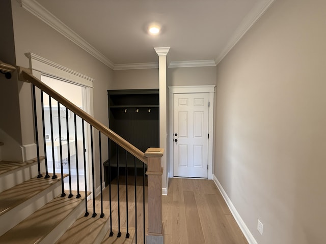 foyer with ornamental molding, stairs, baseboards, and wood finished floors
