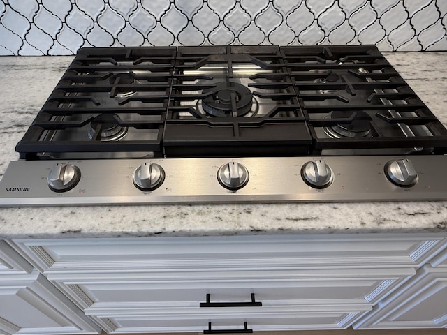 details featuring stove and light stone countertops