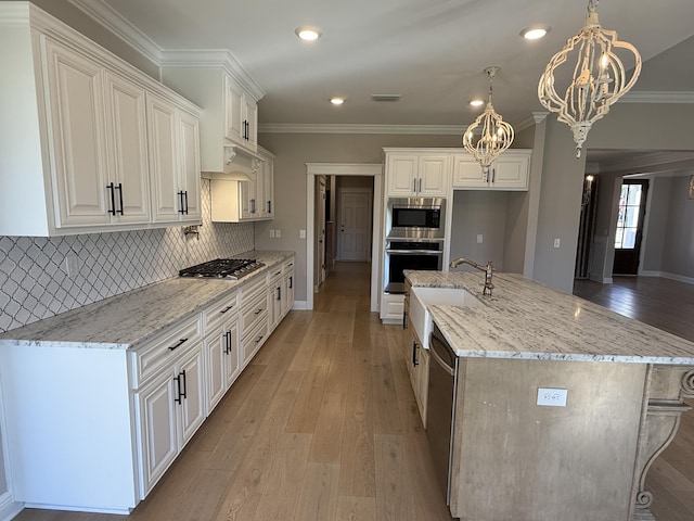 kitchen featuring a sink, stainless steel appliances, a chandelier, and light wood finished floors