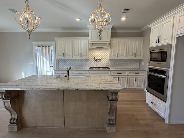 kitchen featuring crown molding, light stone counters, a chandelier, and stainless steel appliances