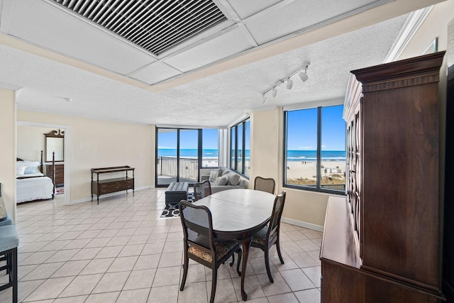 9850 S Thomas Dr Unit 205W, Panama City Beach, FL 32408 - dining room featuring light tile patterned flooring, a healthy amount of sunlight, and a textured ceiling