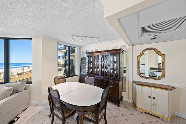 9850 S Thomas Dr Unit 205W, Panama City Beach, FL 32408 - dining area with light tile patterned floors, visible vents, a textured ceiling, and baseboards