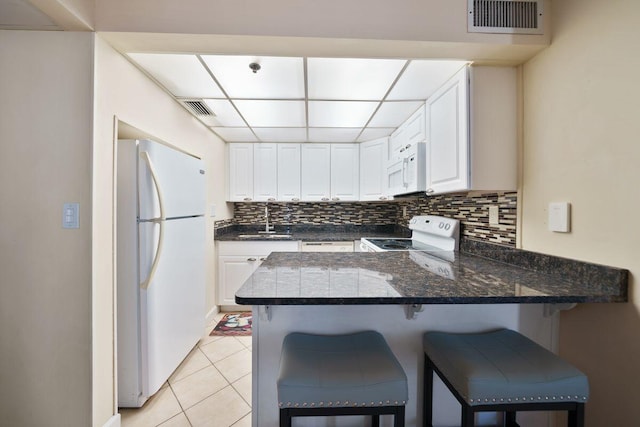 9850 S Thomas Dr Unit 205W, Panama City Beach, FL 32408 - kitchen with visible vents, a sink, tasteful backsplash, white appliances, and a peninsula