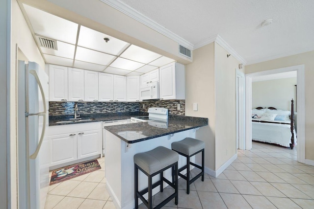 9850 S Thomas Dr Unit 205W, Panama City Beach, FL 32408 - kitchen featuring visible vents, light tile patterned floors, white cabinets, white appliances, and a sink
