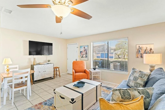 living area with light tile patterned floors, visible vents, baseboards, and ceiling fan
