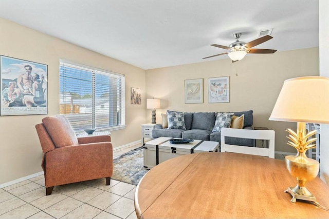 living room with light tile patterned floors, visible vents, baseboards, and ceiling fan