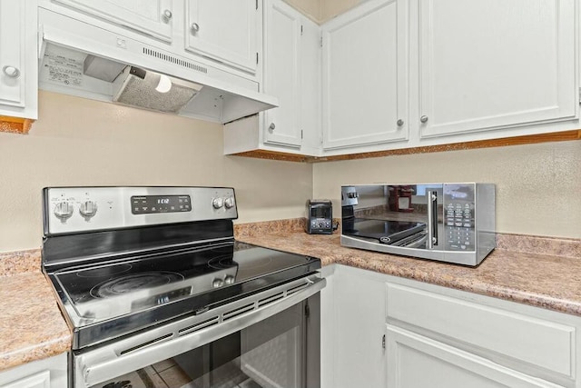 kitchen with under cabinet range hood, light countertops, and electric stove
