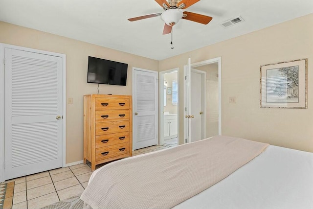 bedroom featuring light tile patterned floors, visible vents, connected bathroom, and ceiling fan