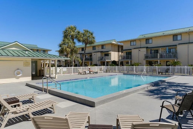pool with a residential view, a patio, and fence