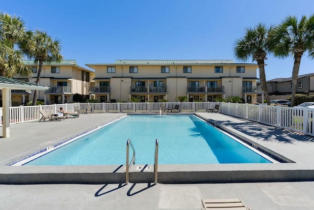 community pool with a patio and fence