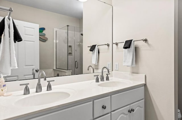 full bath featuring double vanity, a stall shower, and a sink