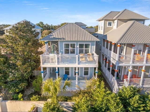 rear view of property with metal roof and a balcony