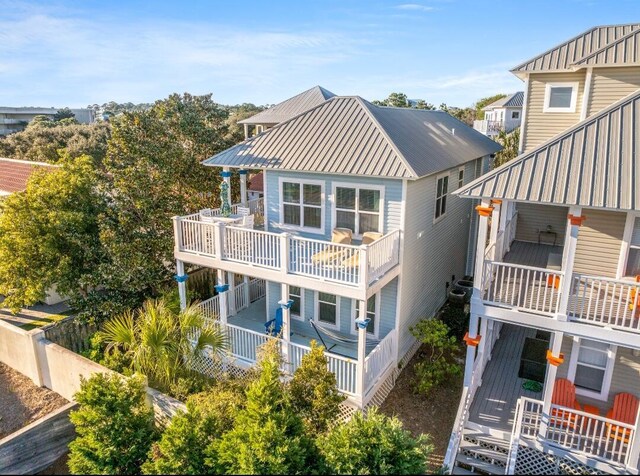 back of house featuring a balcony and metal roof