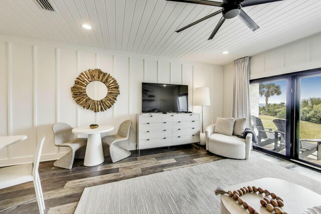 living room featuring wood ceiling, wood finished floors, a decorative wall, visible vents, and ceiling fan