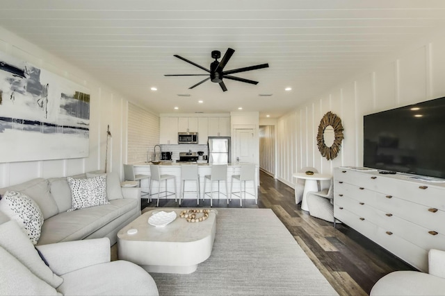 living area featuring a ceiling fan, recessed lighting, and dark wood finished floors