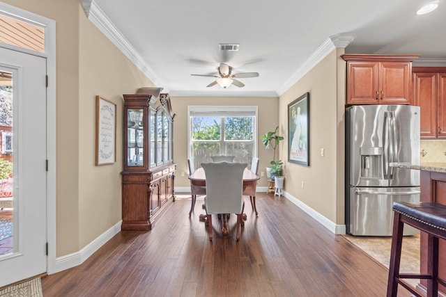 dining space featuring ornamental molding, ceiling fan, dark wood-style flooring, and baseboards