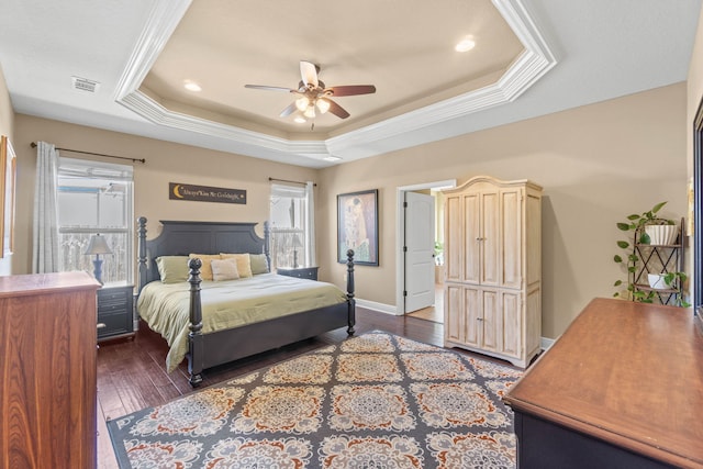 bedroom with visible vents, crown molding, a tray ceiling, and wood-type flooring