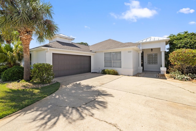 view of front facade with a garage, stucco siding, and driveway