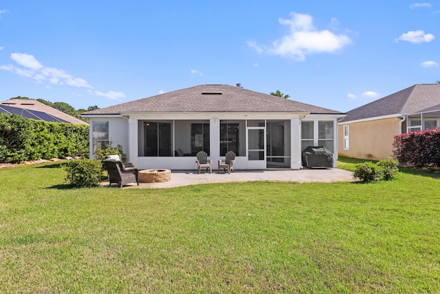 rear view of property featuring a shingled roof, a fire pit, a sunroom, a lawn, and a patio