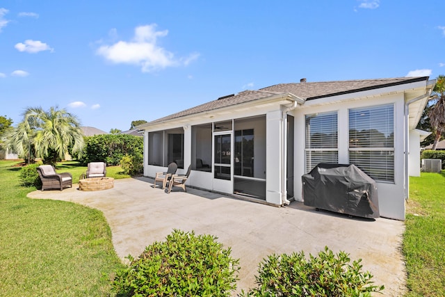 back of house featuring a patio area, a fire pit, a sunroom, and a lawn