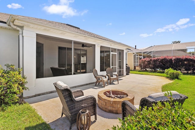 view of patio featuring a sunroom and an outdoor fire pit
