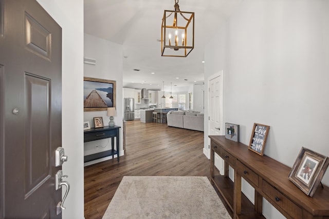 foyer entrance with dark wood-type flooring, a notable chandelier, and recessed lighting