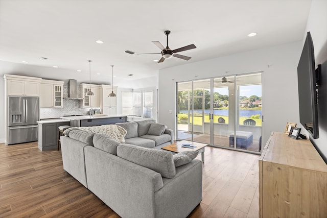 living room with wood finished floors, a ceiling fan, and recessed lighting