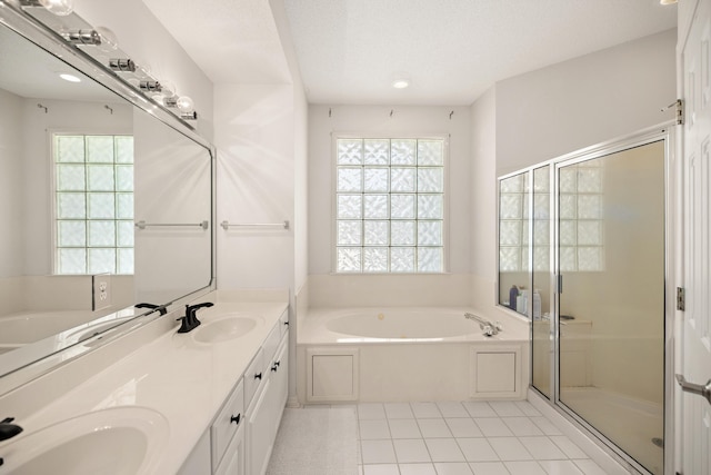 bathroom with a stall shower, a garden tub, and a sink