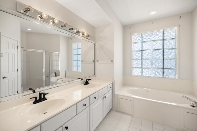bathroom with a stall shower, a garden tub, and a sink
