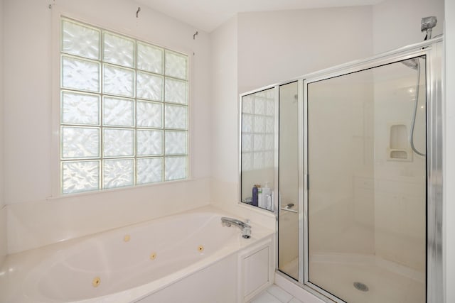 bathroom featuring plenty of natural light, a stall shower, and a tub with jets