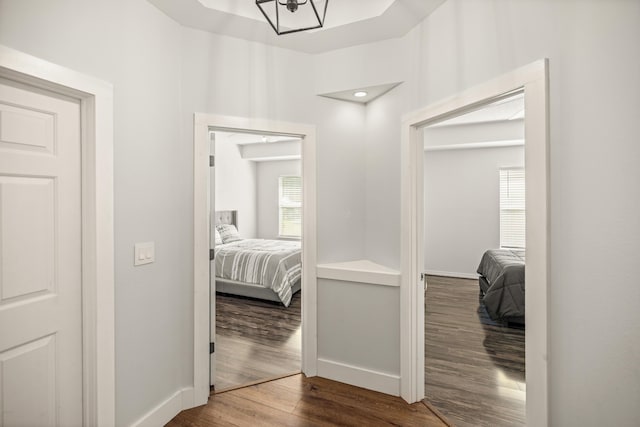 hallway featuring wood finished floors and baseboards