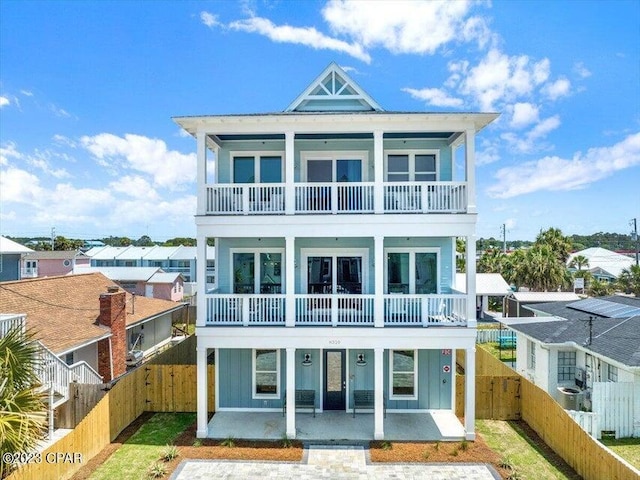 8320 Surf Dr, Panama City Beach, FL 32408 - back of house with a patio area, a balcony, board and batten siding, and a fenced backyard