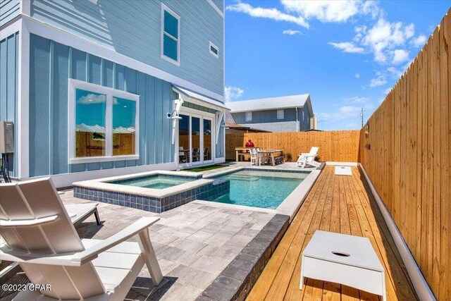 8320 Surf Dr, Panama City Beach, FL 32408 - view of swimming pool with a fenced backyard, french doors, a pool with connected hot tub, and a deck