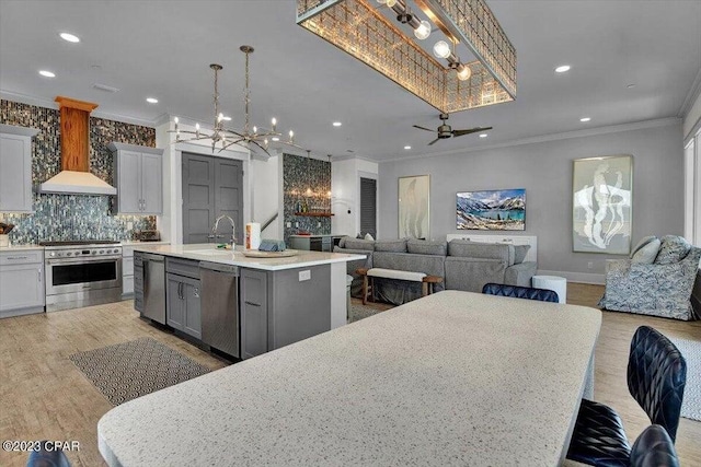 8320 Surf Dr, Panama City Beach, FL 32408 - kitchen featuring a kitchen island with sink, ornamental molding, a sink, stainless steel appliances, and custom exhaust hood