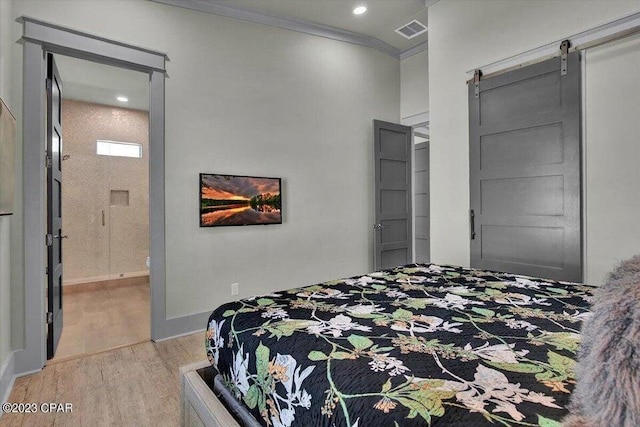 8320 Surf Dr, Panama City Beach, FL 32408 - bedroom featuring visible vents, crown molding, a barn door, ensuite bathroom, and wood finished floors