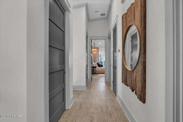 8320 Surf Dr, Panama City Beach, FL 32408 - hall with an inviting chandelier, baseboards, visible vents, and light wood finished floors