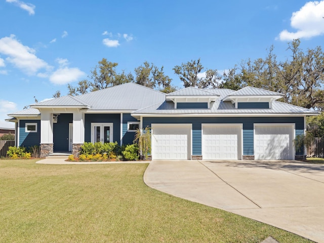 view of front of home featuring metal roof, a garage, concrete driveway, a front yard, and a standing seam roof