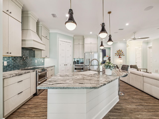 kitchen featuring open floor plan, tasteful backsplash, dark wood-style flooring, stainless steel appliances, and a sink