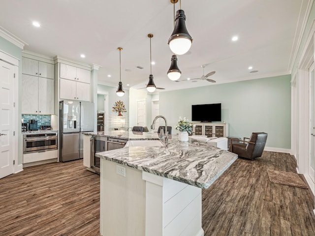 kitchen with crown molding, refrigerator with ice dispenser, a sink, stainless steel oven, and dark wood-type flooring